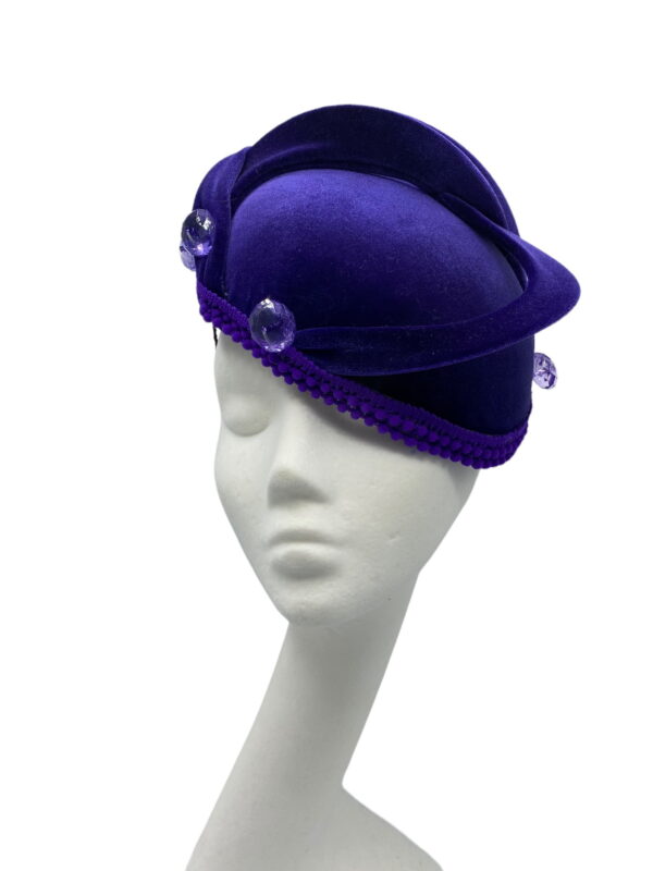 Cadbury purple velvet hat with purple swirl and finished with button detail to each end of swirl.